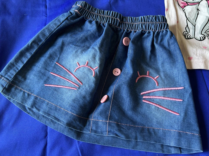 Blue denim shorts with pink embroidered designs