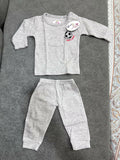 Gray baby outfit with long-sleeve top and pants on a textured surface