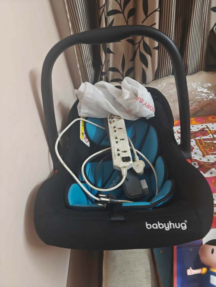 BABYHUG Amber Car Seat Cum Rocker in Almost New condition, featuring comfortable padded seating, safety harness, ergonomic carry handle, protective canopy, and versatile rocking function for convenient infant travel and supervised relaxation.