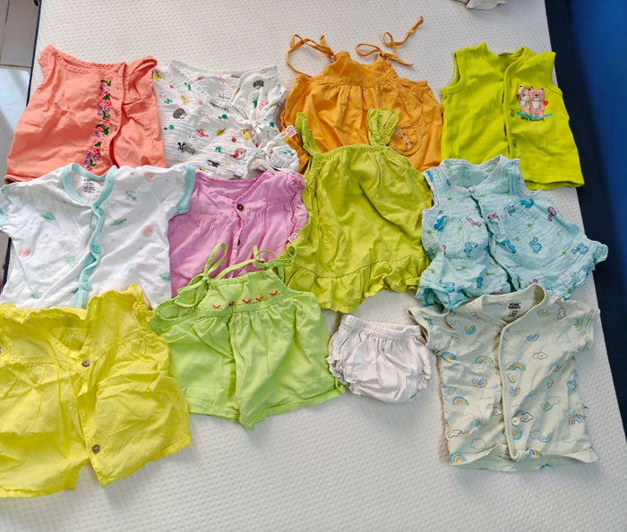Collection of colorful baby clothes on a white surface