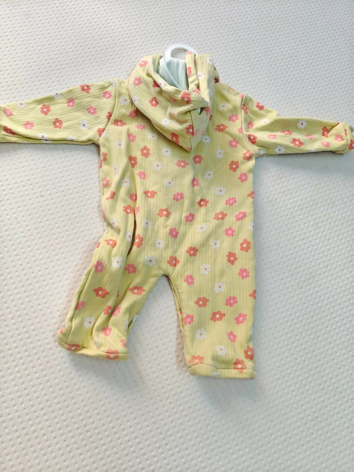 Yellow baby romper with pink floral pattern on a light gray background