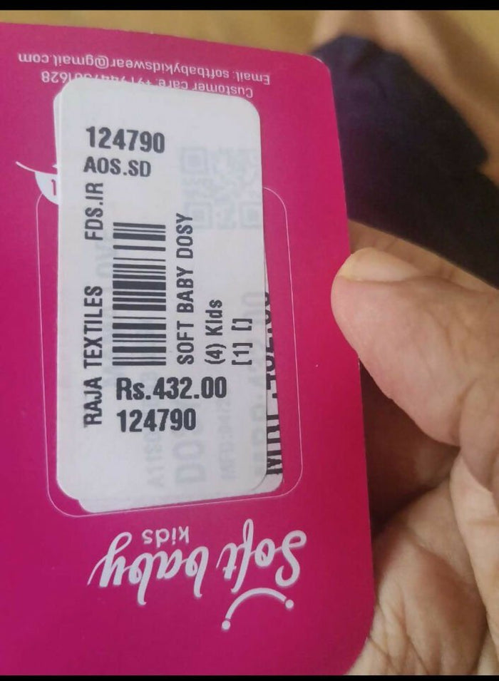 Close-up of a product label with text and a barcode on a pink background.