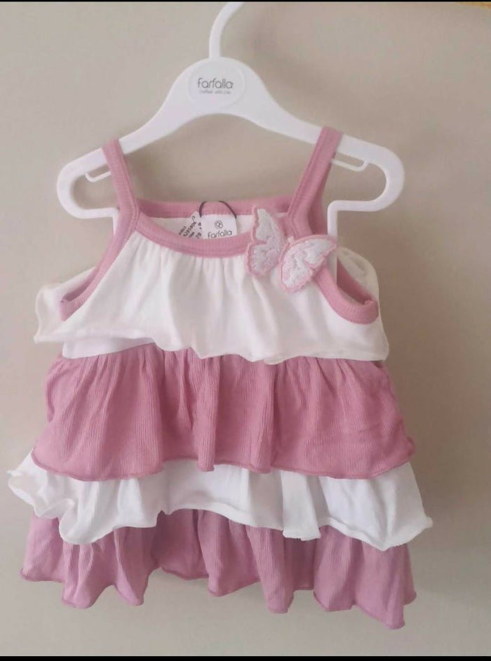 Pink and white baby dress on a hanger against a plain background