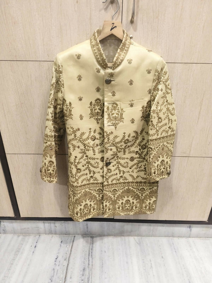 Decorative jacket with intricate patterns on a hanger against a neutral background
