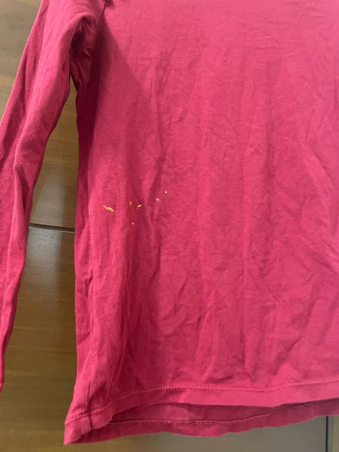 Pink long-sleeve shirt on a wooden surface
