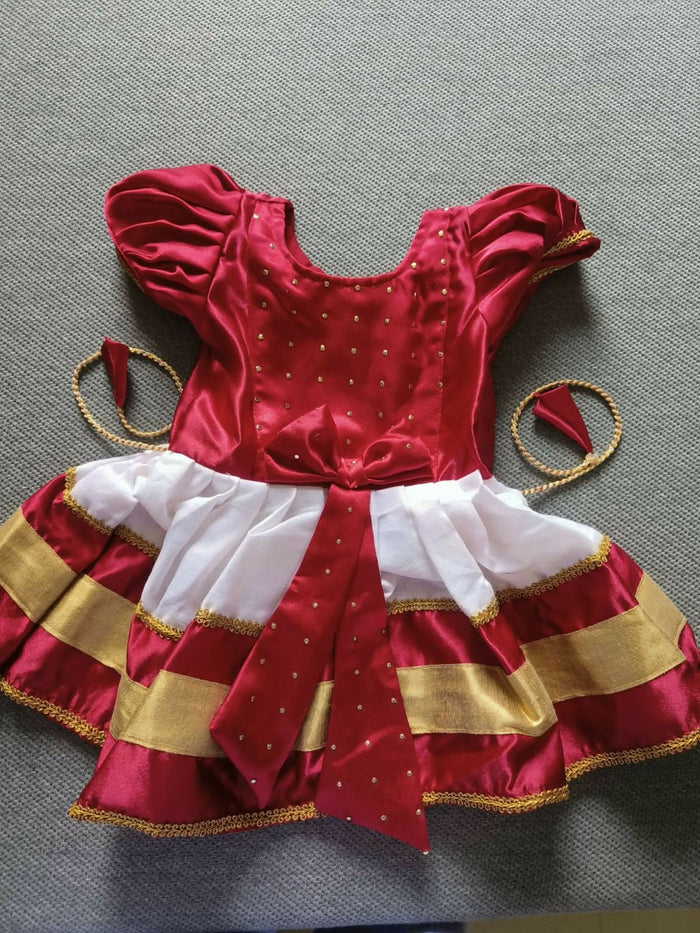 Dress your baby girl in the South Indian Style Silk Partywear Dress – a luxurious and elegant outfit perfect for weddings and festivals, showcasing vibrant colors and traditional design elements.