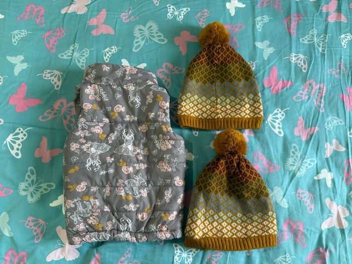 Floral-patterned bag and yellow beanie on a blue fabric background with butterfly designs